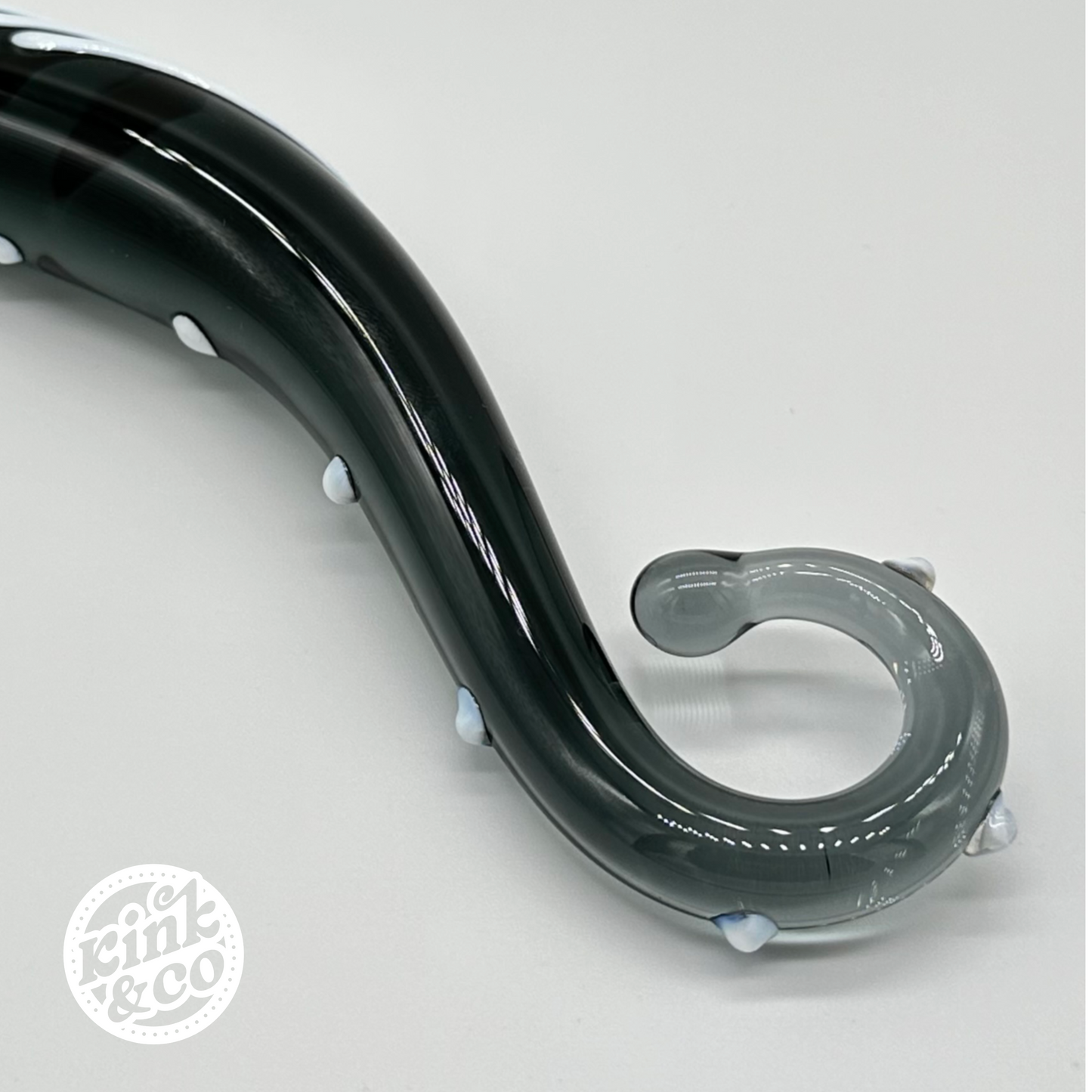 Close up of the handle of a black glass sex toy 